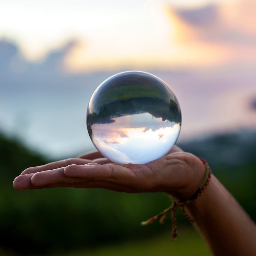 Hand holding Acrylic Contact Ball in blurred nature background