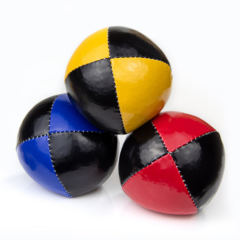 One ball on top of other juggling balls - black with red/ yellow/ blue colours