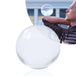 80mm Clear Contact Juggling Ball; Guy balances with glass ball on bent elbow; Inverted panorama of city in reflection of ball. 