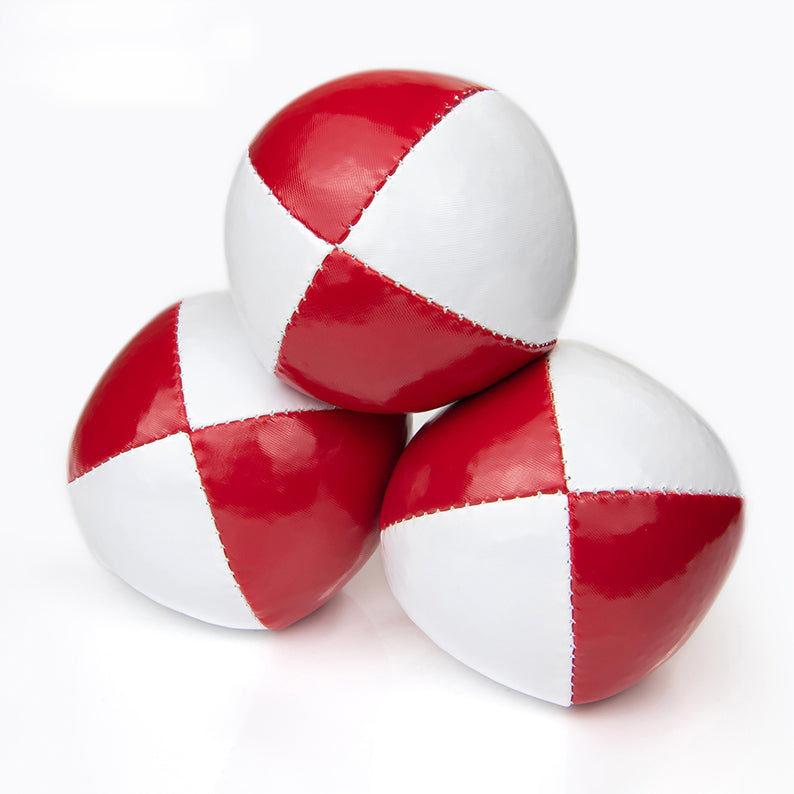 One ball on top of other two juggling balls - red / white colours