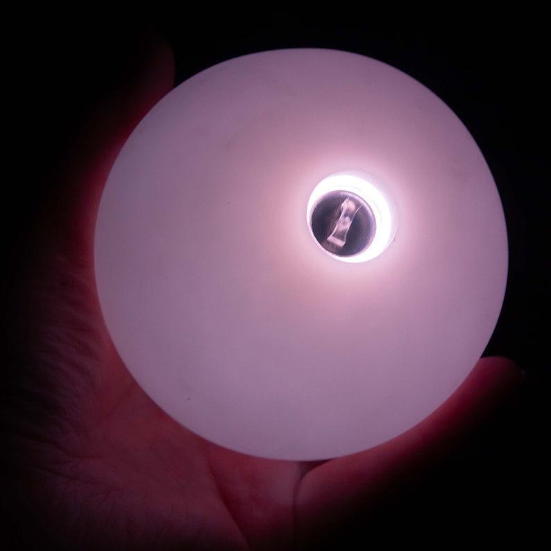 Close - up of LED Contact Ball glowing white in hand